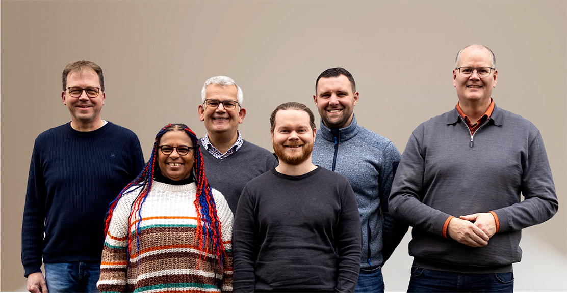 Menschen aus dem INVOLIA Team vor grauem Hintergrund